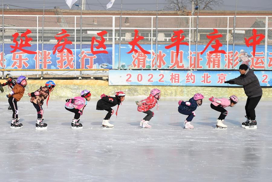 Students at Beijing Yanqing Taipingzhuang Central Primary School practice skating on the ice rink. (Photo/Xinhua)
The Beijing Yanqing Taipingzhuang Central Primary School is a full-time rural primary school. And Wang\'s training rink is located in the east campus of the primary school.

It was originally a farmland where teachers and students planted corn and vegetables. But in November 2016, with the support of the Yanqing district education committee, the Taipingzhuang Central Primary School spent more than 800,000 yuan ($118,092) to build this 1,800 square meter seasonal ice rink, and equipped students with skates and protective gear.

The school then hired a retired physical education teacher, Li Chunyu from Manzhouli, Inner Mongolia, as the children\'s skating coach.