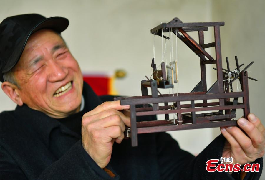 Wang Xiangcheng shows his handmade miniature agricultural tools in his home in a village in Baoding City, North China\'s Hebei Province, Feb. 25, 2019. Wang has built more than a dozen sets of models of old farming objects, such as ploughs, carriages, looms and stone mills, at a scale of 1:8. He said he hoped his models could provide younger generations with a glimpse of what life was like in the countryside in years past. (Photo: China News Service/Zhai Yujia)