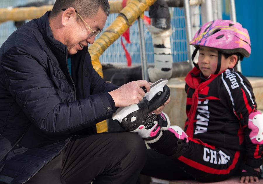 Ding Jianpei, the headmaster of the school (left in the above picture), hopes the students can really enjoy winter sports while growing up.  (Photo/Xinhua)