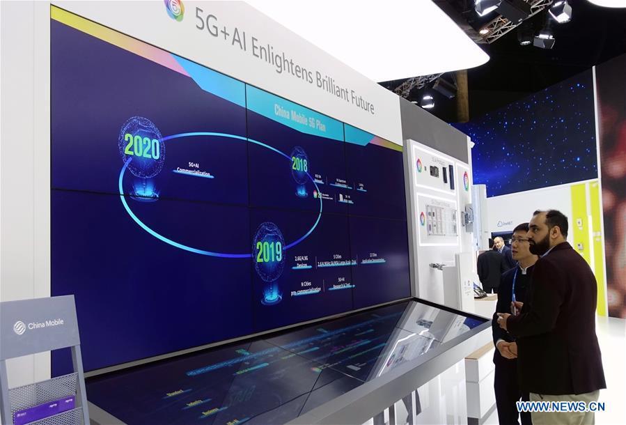 A visitor learns China Mobile 5G plan at Mobile World Congress (MWC 2019) in Barcelona, Spain, Feb. 26, 2019. The four-day MWC 2019 opened its door on Monday, which presents the newest 5G products of the high-tech giants from all around the world. (Xinhua/Guo Qiuda)