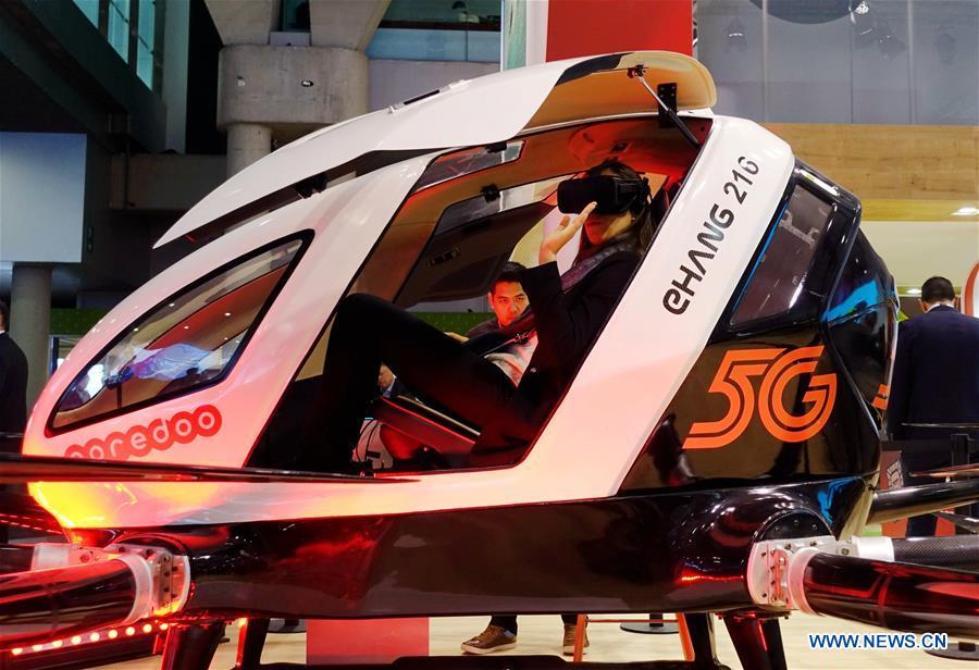 A visitor tries a 5G aerial taxi of Qatar\'s Ooredoo at Mobile World Congress (MWC 2019) in Barcelona, Spain, Feb. 26, 2019. The four-day MWC 2019 opened its door on Monday, which presents the newest 5G products of the high-tech giants from all around the world. (Xinhua/Guo Qiuda)