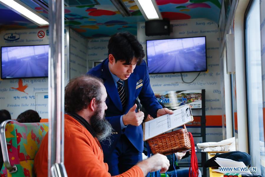 Lee Tae-hyun (R), a trainman and tour guide, registers a passenger\'s information onboard a DMZ train, South Korea, Feb. 20, 2019. Created in 1953 when the three-year Korean War ended with armistice, the Demilitarized Zone (DMZ) has long been a symbol of both confrontation and peace as tensions or rapprochement across the inter-Korean border can be felt firsthand in the 250-km-long strip of no-man\'s land. The DMZ Train departed Seoul Station for Dorasan Station, the northernmost station of the ROK just about 50 km north of Seoul and only 700 meters south of the southern boundary of the 4-km-wide DMZ. (Xinhua/Wang Jingqiang)