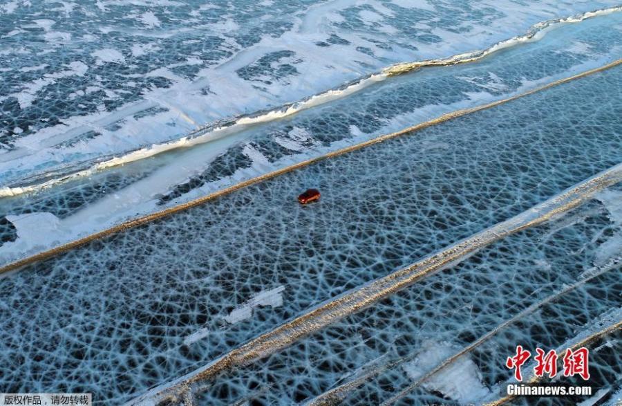 A car drives on the frozen surface of the Yenisei River, which looks like a spider web, in southern Krasnoyarsk, Russia, March 3, 2019. (Photo/IC)
