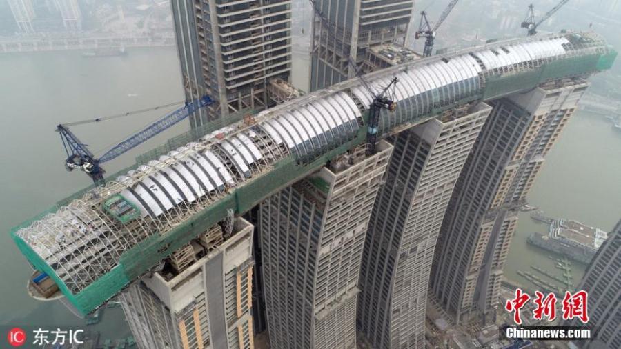 Construction work continues on the Raffles City Chongqing complex in Southwest China\'s Chongqing Municipality. Located at the confluence of the Yangtze and Jialing rivers, Raffles City Chongqing has been designed by world-renown architect Moshe Safdie, who drew inspiration from the region\'s thousand years of waterway transportation history. Now, the eighth and final skyscraper of Raffles City Chongqing has been topped out. Four of the enormous structures are linked by The Crystal - a 32.5-meter-wide, 26.5-meter-tall \