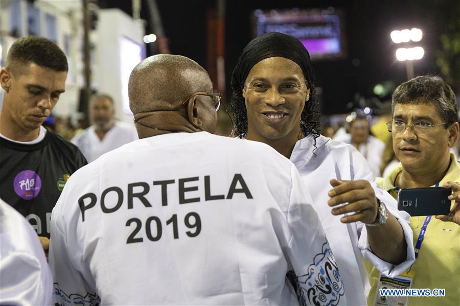 Brazil\'s former football player Ronaldinho (2nd R) hugs a member of samba school \