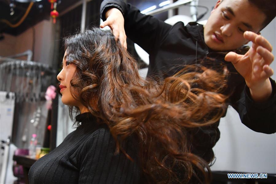 A woman has her hair done at a barber shop in Tianshui, northwest China\'s Gansu Province, March 5, 2019. Along with China\'s reform and opening-up starting from 1978, Chinese women have refreshed their images year after year, which can be simply seen from their hairstyles. Women\'s hairstyles, just like a mirror, reflect fashion changes and most importantly, Chinese women\'s increasingly diversified definition of beauty. (Xinhua/Chen Bin)