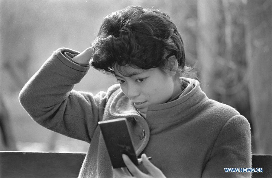 A woman arranges her wig in the mirror in Chengdu, capital of southwest China\'s Sichuan Province, March 3, 1990. Along with China\'s reform and opening-up starting from 1978, Chinese women have refreshed their images year after year, which can be simply seen from their hairstyles. Women\'s hairstyles, just like a mirror, reflect fashion changes and most importantly, Chinese women\'s increasingly diversified definition of beauty. (Xinhua/Chen Xie)