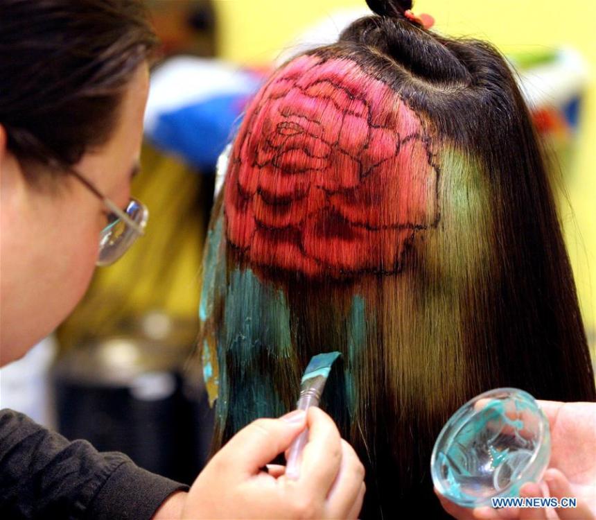 A hairdresser applies dye to a model\'s hair in Luoyang, central China\'s Henan Province, April 30, 2005. Along with China\'s reform and opening-up starting from 1978, Chinese women have refreshed their images year after year, which can be simply seen from their hairstyles. Women\'s hairstyles, just like a mirror, reflect fashion changes and most importantly, Chinese women\'s increasingly diversified definition of beauty. (Xinhua/Zhang Xiaoli)