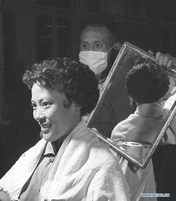 A woman looks into a mirror at a barber shop in Xidan of Beijing, capital of China, Nov. 10, 1959. Along with China\'s reform and opening-up starting from 1978, Chinese women have refreshed their images year after year, which can be simply seen from their hairstyles. Women\'s hairstyles, just like a mirror, reflect fashion changes and most importantly, Chinese women\'s increasingly diversified definition of beauty. (Xinhua/An Kang)
