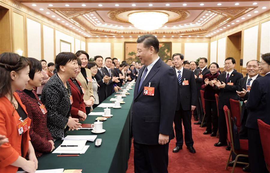 Chinese President Xi Jinping, also general secretary of the Communist Party of China (CPC) Central Committee and chairman of the Central Military Commission, talks with female deputies when joining deliberation with deputies from central China\'s Henan Province at the second session of the 13th National People\'s Congress in Beijing, capital of China, March 8, 2019. Xi extended greetings and best wishes to female lawmakers, political advisors and staff workers at the ongoing \