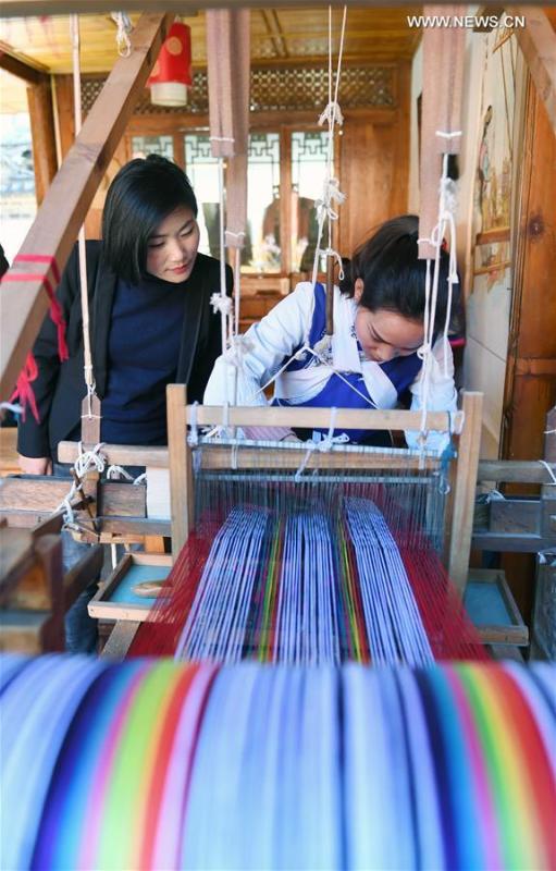 Fan Yongzhen (L), a deputy to the 13th National People\'s Congress (NPC), carries out a research on textile weaving skills of Naxi ethnic group in Lijiang ancient town, southwest China\'s Yunnan Province, Feb. 13, 2019.