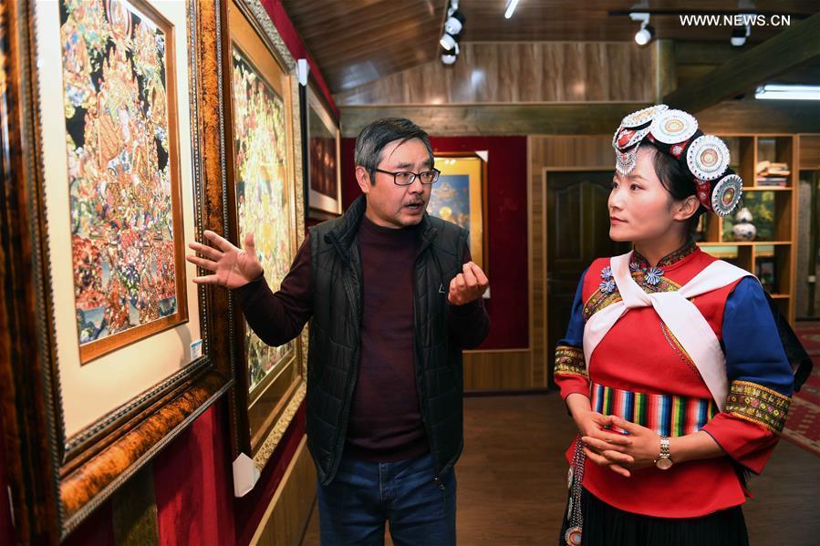 Fan Yongzhen (R), a deputy to the 13th National People\'s Congress (NPC), carries out a research on Thangka painting with dianxiu embroidery at Baisha Old Town of Yulong Naxi Autonomous County in Lijiang, southwest China\'s Yunnan Province, Feb. 13, 2019. (Xinhua/Yang Zongyou)