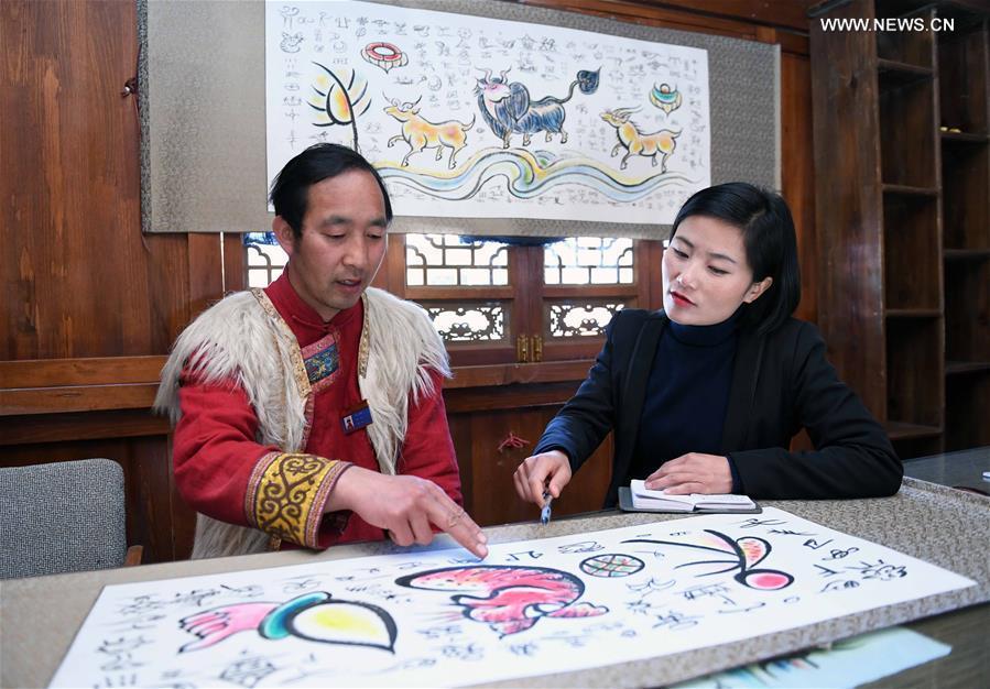 Fan Yongzhen (R), a deputy to the 13th National People\'s Congress (NPC), carries out a research on the Dongba pictographic language at Yushuizhai Village of Yulong Naxi Autonomous County in Lijiang, southwest China\'s Yunnan Province, Feb. 13, 2019. (Xinhua/Yang Zongyou)