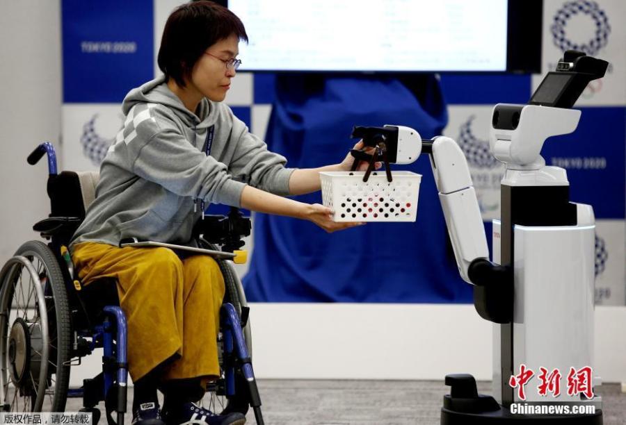 Toyota\'s Human Support Robot (HSR) delivers a basket to a woman in a wheelchair at a demonstration of Tokyo 2020 Robot Project for Tokyo 2020 Olympic Games in Tokyo, Japan, March 15, 2019. (Photo/Agencies)