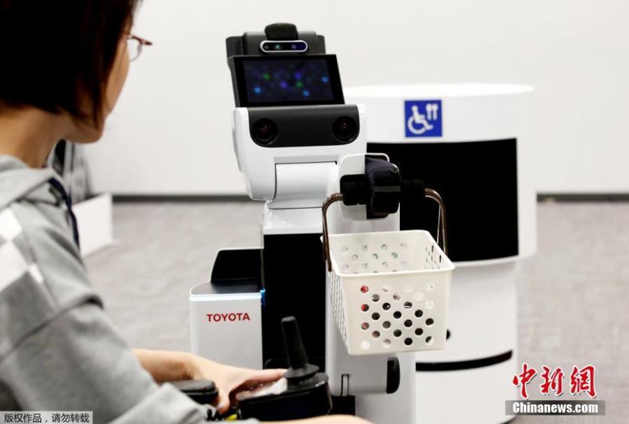 Toyota\'s HSR (Human Support Robot) delivers a basket to a woman in a wheelchair at a demonstration of Tokyo 2020 Robot Project for Tokyo 2020 Olympic Games in Tokyo, Japan, March 15, 2019. (Photo/Agencies)