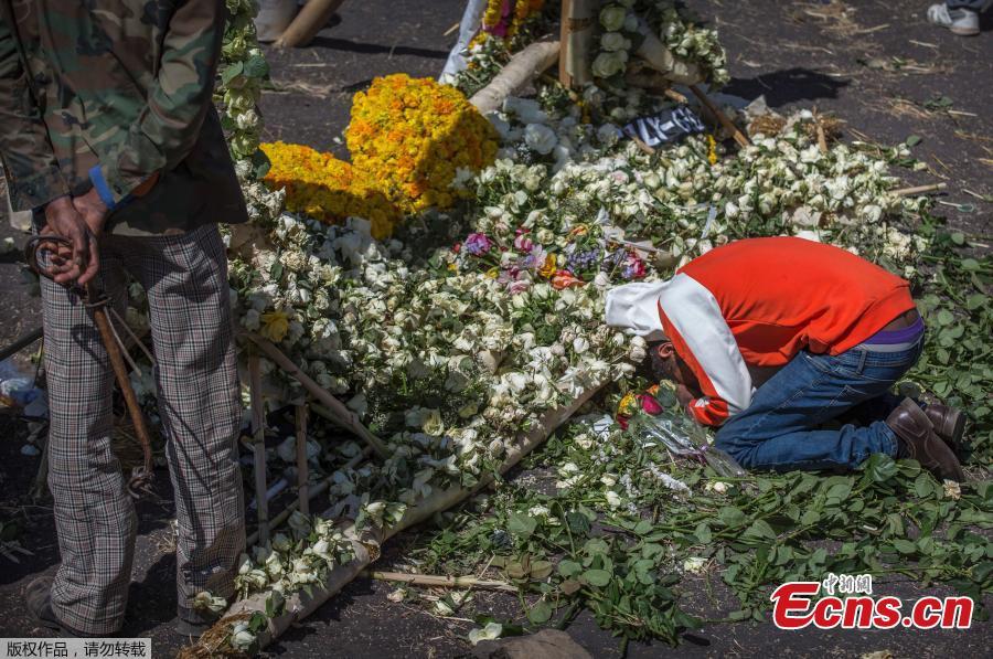 A relative of the crashed Ethiopian jet victim mourns and grieves next to a floral tribute at the scene where the Ethiopian Airlines Boeing 737 Max 8 crashed shortly after takeoff killing all 157 on board, near Bishoftu, south-east of Addis Ababa, in Ethiopia Friday, March 15, 2019. (Photo/Agencies)