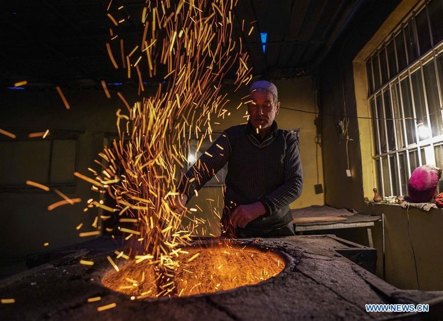 A baker puts the wood fire in an oven used to bake \