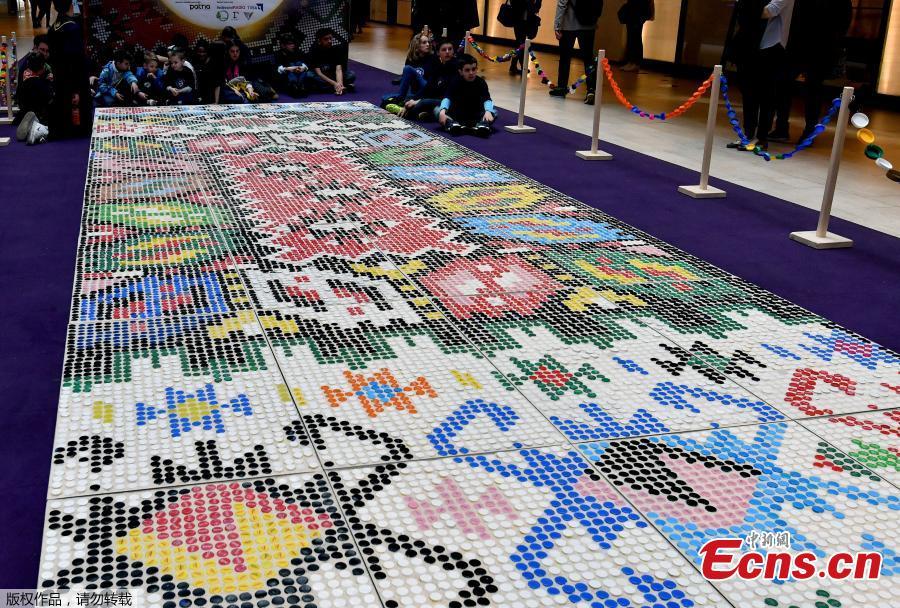 \'Bosnian qillim\' carpet made of plastic bottle caps in colors and patterns typical for Bosnian traditional wool carpet is displayed at Sarajevo City Center mall to mark the Global Recycling Day, March 18, 2019. The bottle cap carpet, made by 700 citizens of Sarajevo, covers 30 square meters of surface and was made using a total of 25,000 plastic bottle caps. (Photo/Agencies)