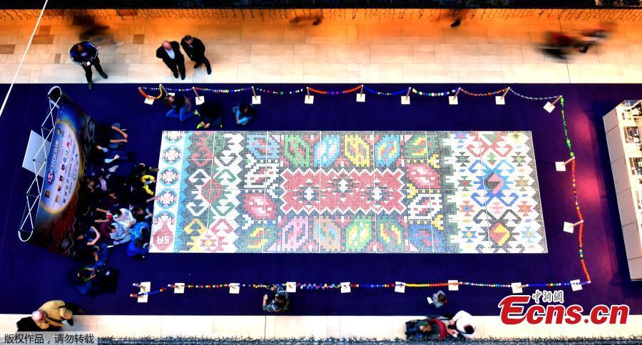 \'Bosnian qillim\' carpet made of plastic bottle caps in colors and patterns typical for Bosnian traditional wool carpet is displayed at Sarajevo City Center mall to mark the Global Recycling Day, March 18, 2019. The bottle cap carpet, made by 700 citizens of Sarajevo, covers 30 square meters of surface and was made using a total of 25,000 plastic bottle caps. (Photo/Agencies)