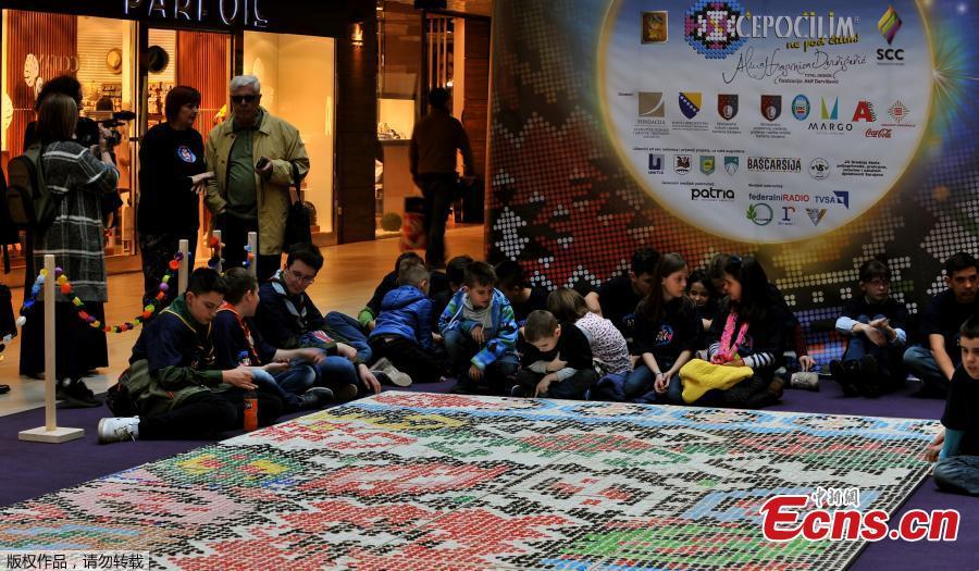 \'Bosnian qillim\' carpet made of plastic bottle caps in colors and patterns typical for Bosnian traditional wool carpet is displayed at Sarajevo City Center mall to mark the Global Recycling Day, March 18, 2019. The bottle cap carpet, made by 700 citizens of Sarajevo, covers 30 square meters of surface and was made using a total of 25,000 plastic bottle caps. (Photo/Agencies)