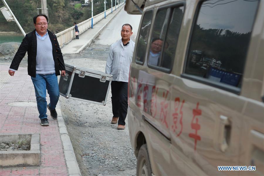 Huang Yiyin (L) and his assistant Wang Yangqing carry the screening facilities in Santangmen Village of Benchu Town, Tianzhu County of Miao and Dong Autonomous Prefecture of Qiandongnan, southwest China\'s Guizhou Province, March 19, 2019. Local authority in Tianzhu County established special fund to show movies in rural areas. In 2018, a total of 14 voluntary projectionists in Tianzhu showed 3,979 movies in villages within the county. (Xinhua/Ou Dongqu)