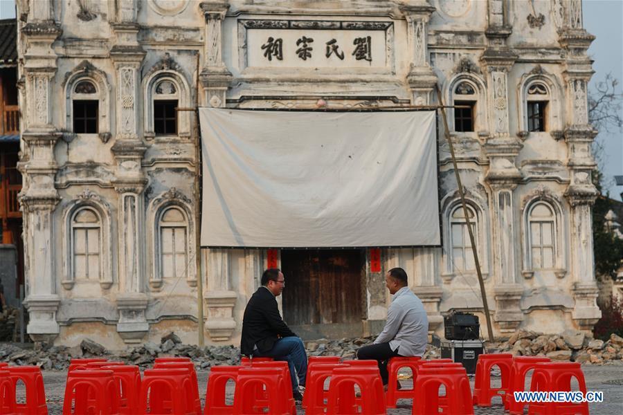 Huang Yiyin (L) and his assistant Wang Yangqing chat before screening a movie in Santangmen Village of Benchu Town, Tianzhu County of Miao and Dong Autonomous Prefecture of Qiandongnan, southwest China\'s Guizhou Province, March 19, 2019. Local authority in Tianzhu County established special fund to show movies in rural areas. In 2018, a total of 14 voluntary projectionists in Tianzhu showed 3,979 movies in villages within the county. (Xinhua/Ou Dongqu)