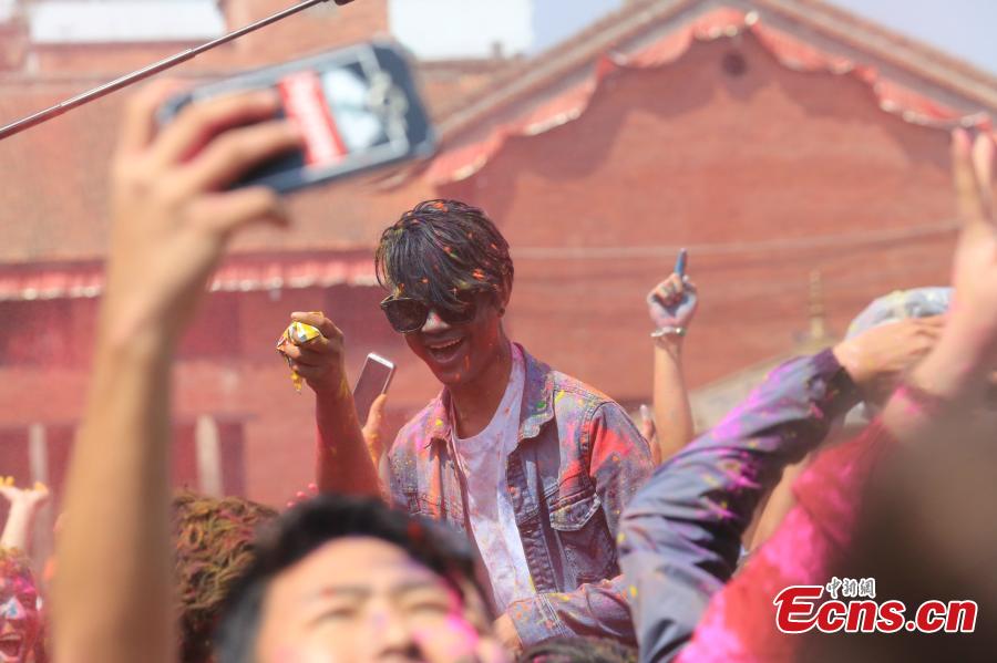 People celebrate Holi, the Festival of Colours, in Kathmandu, Nepal, March 20, 2019. Revellers, young and old, alike, celebrated the festival by smearing colourful powders and throwing colours and water to each other. (Photo: China News Service/Zhang Chenyi)