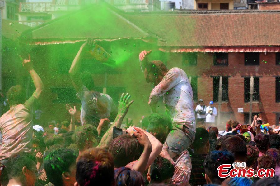 People celebrate Holi, the Festival of Colours, in Kathmandu, Nepal, March 20, 2019. Revellers, young and old, alike, celebrated the festival by smearing colourful powders and throwing colours and water to each other. (Photo: China News Service/Zhang Chenyi)