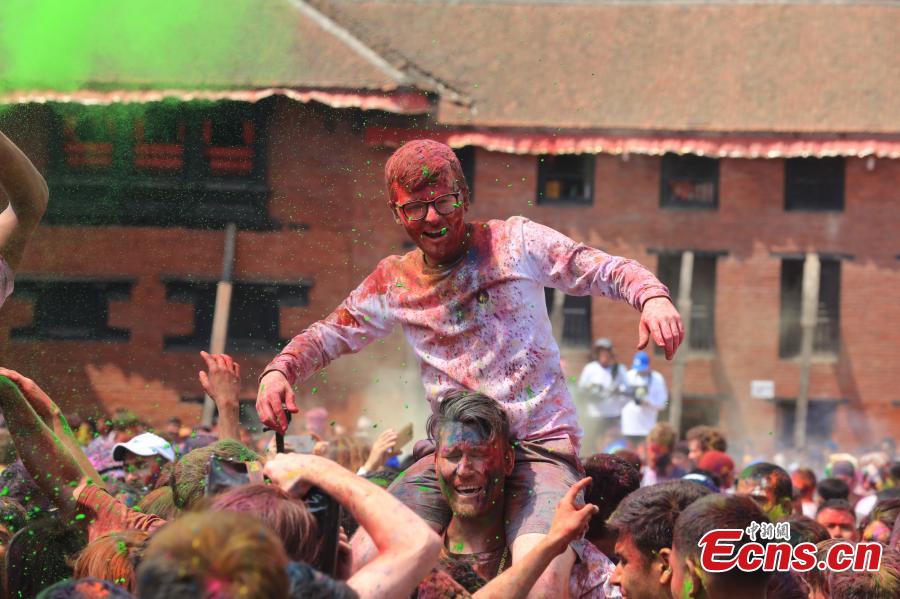 People celebrate Holi, the Festival of Colours, in Kathmandu, Nepal, March 20, 2019. Revellers, young and old, alike, celebrated the festival by smearing colourful powders and throwing colours and water to each other. (Photo: China News Service/Zhang Chenyi)