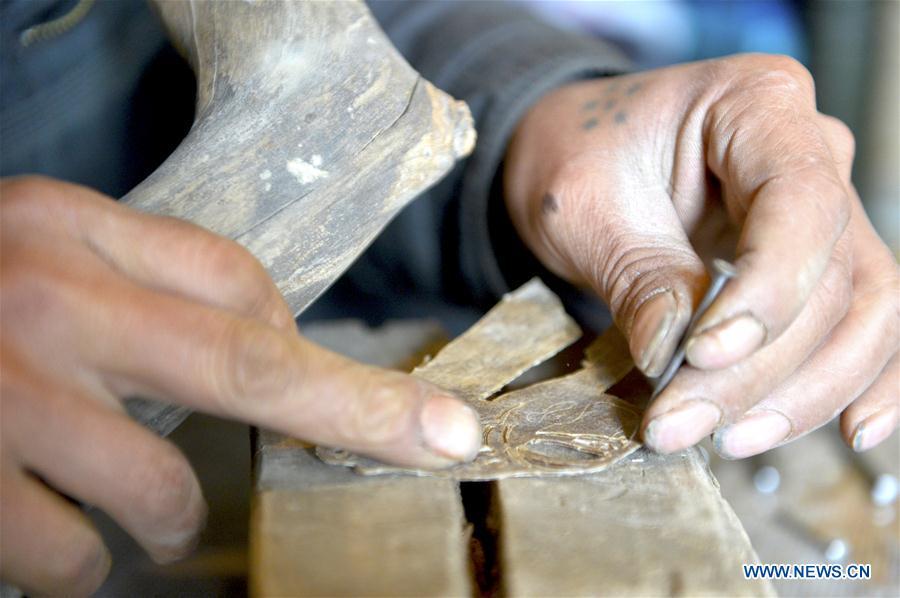 Zhou Zhibing, the apprentice of Pan Mingsheng, carves the shadow puppet at Xinzhai Township of Weiyuan County in Dingxi City, northwest China\'s Gansu province, March 13, 2019. Many local folk artists concentrate on inheriting and passing down the folk art of shadow puppet performing and making in Gansu. They devote themselves to the study of the art and also organize various events to popularize the art. (Xinhua/Li Xiao)