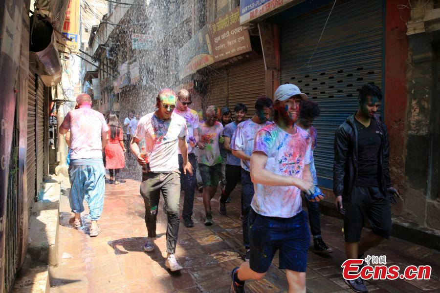 People celebrate Holi, the Festival of Colours, in Kathmandu, Nepal, March 20, 2019. Revellers, young and old, alike, celebrated the festival by smearing colourful powders and throwing colours and water to each other. (Photo: China News Service/Zhang Chenyi)