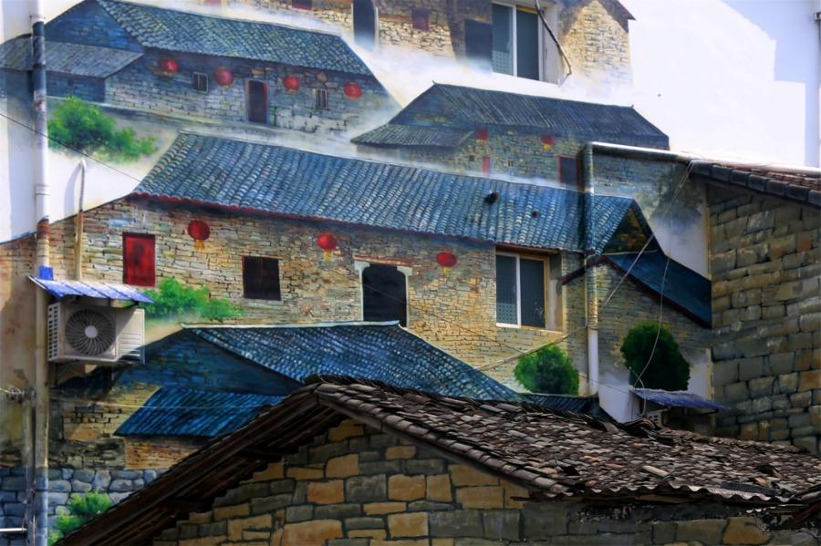 Spring brings beautiful scenery to Puxihe village in Yichang city, Hubei province, March 15, 2019. As the weather becomes warmer, golden cole flowers are blossoming in the region. Meanwhile, local residences are painted with images of animals and agricultural activities, adding liveliness to the landscape. (Photo/Asianewsphoto)