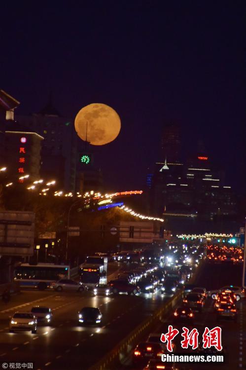 A super snow moon rises over Chang\'an Avenue, a major thoroughfare in Beijing, March 21, 2019. Sky-watchers received a treat as the final supermoon of 2019 arrived on Thursday, also the Spring Equinox, which signals the equal length of day and night time. A supermoon occurs when a full moon\'s orbit is closest to the Earth.  (Photo/VCG)