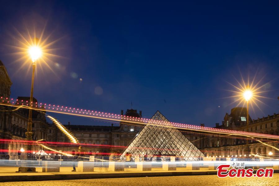 The Louvre Pyramid (Pyramide du Louvre) and the Louvre museum are seen at night on March 21, 2019, in Paris, France.