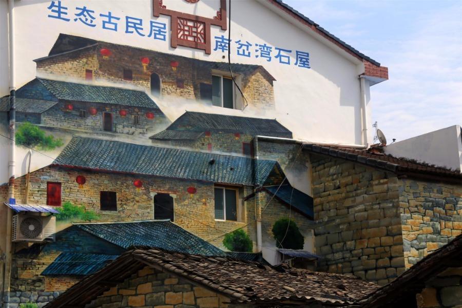 Spring brings beautiful scenery to Puxihe village in Yichang city, Hubei province, March 15, 2019. As the weather becomes warmer, golden cole flowers are blossoming in the region. Meanwhile, local residences are painted with images of animals and agricultural activities, adding liveliness to the landscape. (Photo/Asianewsphoto)