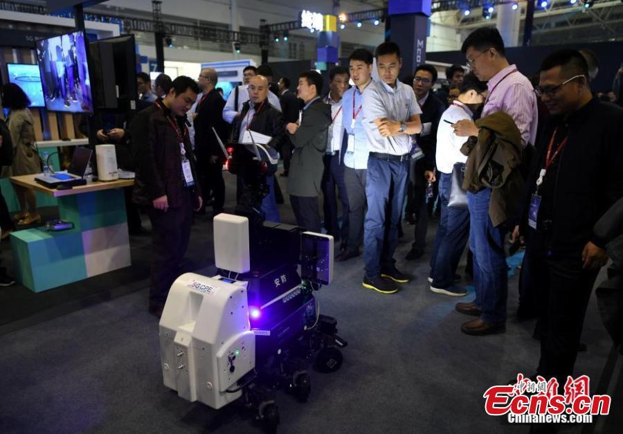 People look at a security robot during the Huawei China Eco-Partner Conference 2019 at the Fuzhou Strait International Conference & Exhibition Center in Fuzhou, Fujian Province, March 21, 2019. (Photo: China News Service/Wang Dongming)