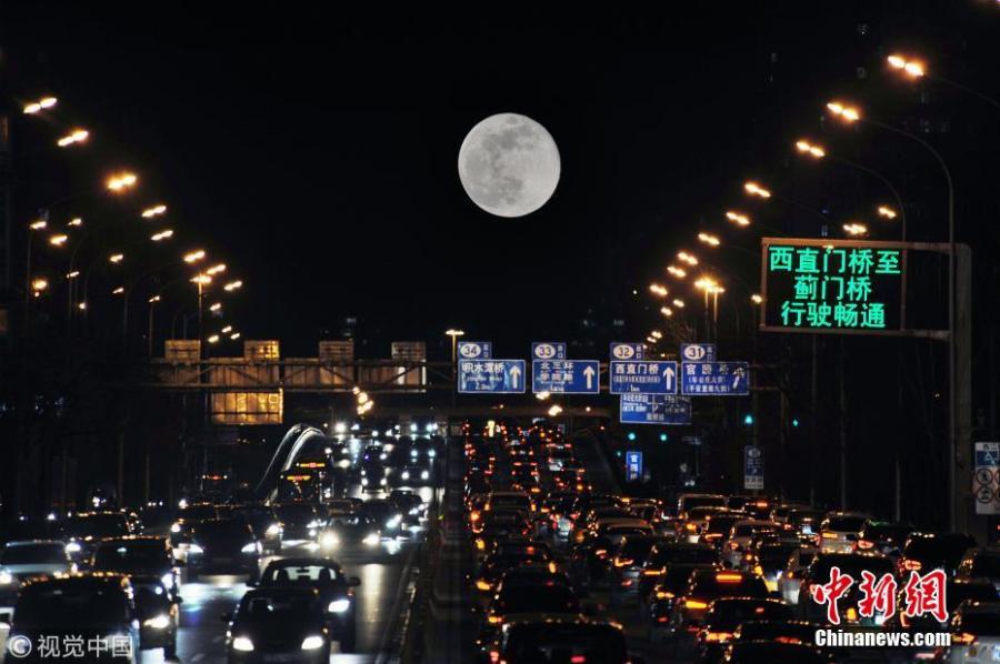 A super snow moon rises over Chang\'an Avenue, a major thoroughfare in Beijing, March 21, 2019. Sky-watchers received a treat as the final supermoon of 2019 arrived on Thursday, also the Spring Equinox, which signals the equal length of day and night time. A supermoon occurs when a full moon\'s orbit is closest to the Earth.  (Photo/VCG)