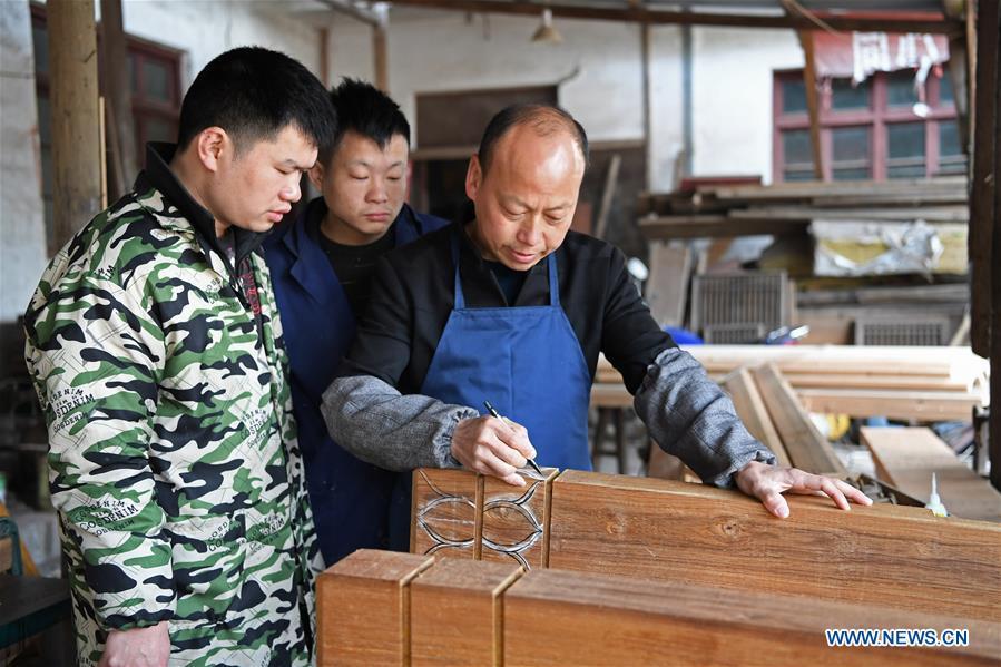Yu Youhong teaches his apprentices the techniques on carvings in Wuyuan County of east China\'s Jiangxi Province, March 19, 2019. The \