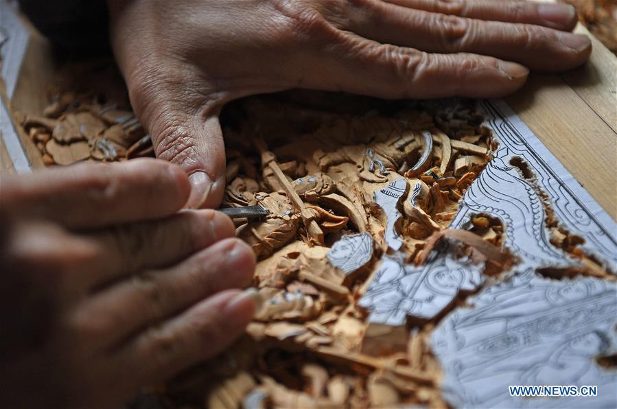 Yu Youhong makes carvings on wood at his studio in Wangkou Village, Wuyuan County of east China\'s Jiangxi Province, March 18, 2019. The \