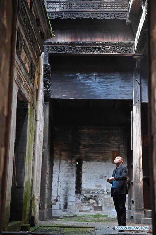 Yu Youhong checks a dilapidated ancient building in Wangkou Village, Wuyuan County of east China\'s Jiangxi Province, March 19, 2019. The \