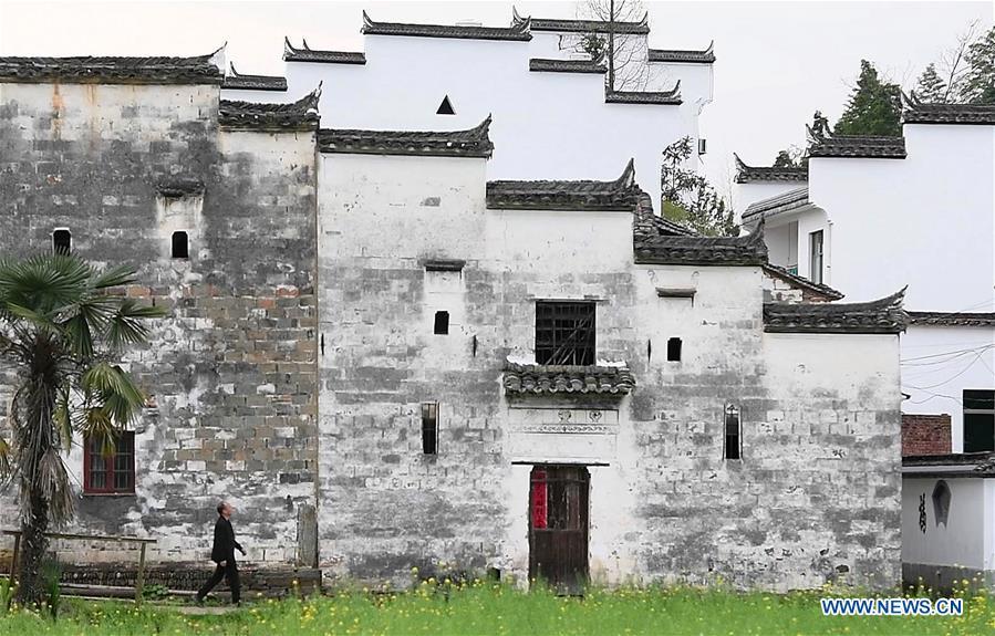 Yu Youhong walks past an ancient building in Zhangcun Village, Wuyuan County of east China\'s Jiangxi Province, March 19, 2019. The \