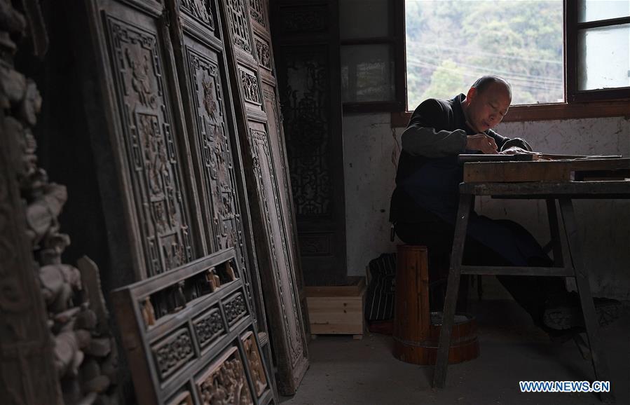 Yu Youhong makes carvings on wood at his studio in Wangkou Village, Wuyuan County of east China\'s Jiangxi Province, March 18, 2019. The \