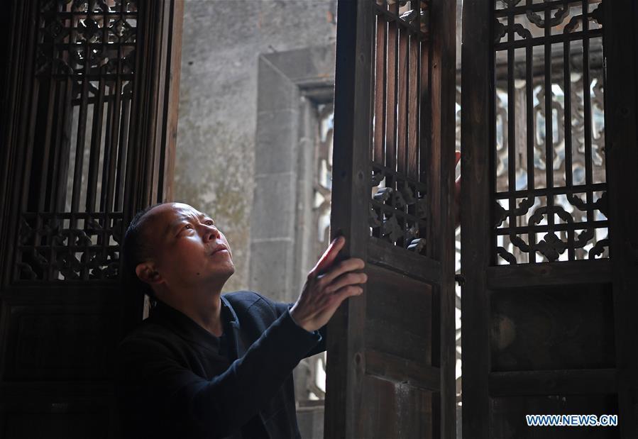 Yu Youhong checks a part of an ancient building in Wangkou Village, Wuyuan County of east China\'s Jiangxi Province, March 19, 2019. The \