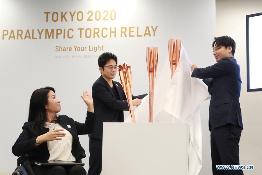 Tokyo 2020 Torch Relay Offical Ambassador Aki Taguchi (L), torch designer Tokujin Yoshioka (C) and Tokyo 2020 Athletes\' Commission member Shintaro Ikeda unveil the samples of the Tokyo 2020 Olympic Torch in Tokyo, Japan, on March 25, 2019. Tokyo 2020 unveiled the sample of the Tokyo 2020 Paralympic Torch on Monday. The color of Tokyo 2020 Paralympic Torch is cherry blossom pink. Aluminum recycled from temporary housing used in areas struck by the Great East Japan Earthquake disaster will be used to manufacture the torch. (Xinhua/Du Xiaoyi)