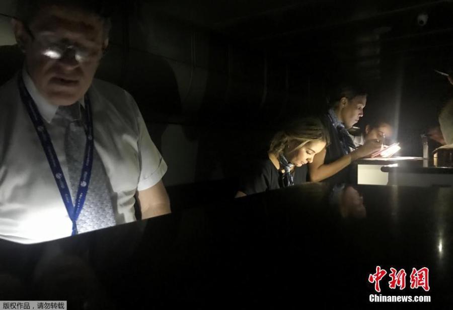 Employees check the boarding passes during a blackout at Simon Bolivar international airport in Caracas, Venezuela March 25, 2019. (Photo/Agencies)