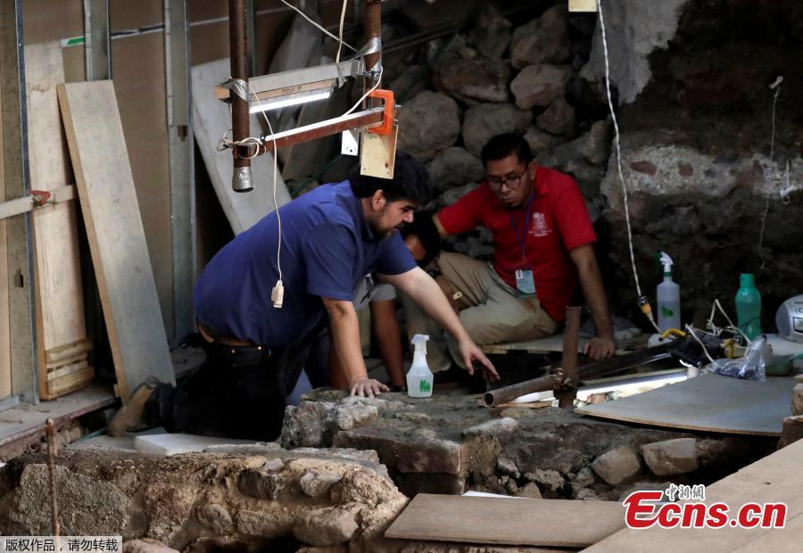 Miguel Baez (L) and Antonio Marin, archaeologists with the National Institute of Anthropology and History (INAH), work at a site where the 500-year-old interior of a partially-excavated stone box shows an Aztec offering that includes the bones of a jaguar with the circular emblem of the war god Huitzilopochtli, as well a layer of coral, the remains of a large number of starfish and shells and found at the steps of the Templo Mayor in downtown Mexico City, Mexico, March 14, 2019. (Photo/Agencies)