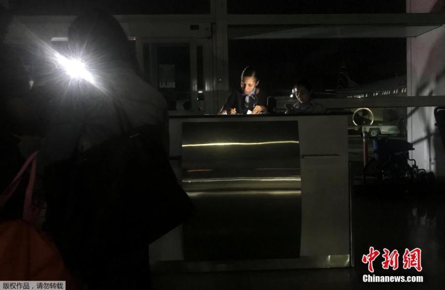 An employee checks boarding passes during a blackout at Simon Bolivar international airport in Caracas, Venezuela March 25, 2019.  (Photo/Agencies)