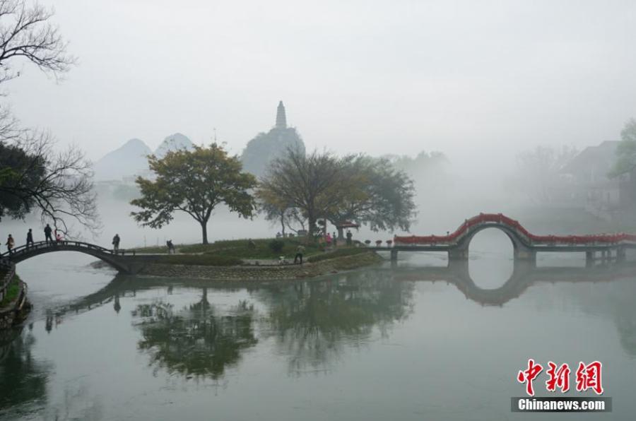 A view of Tashan Mountain surrounded by mist along the riverbanks of the Lijiang River in Guilin City, Guangxi Zhuang Autonomous Region, March 28, 2019. Like a green ribbon flowing through the mountains, the Lijiang River is known for its amazing natural beauty. (Photo: China News Service/Tang Mengxian)