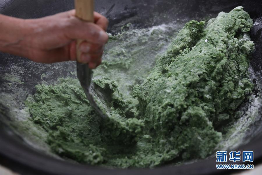 Wild mugwort is pounded before being added to glutinous rice and molded into smooth, silky qingtuan cakes. (Photo/Xinhua)