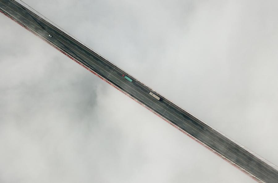 An aerial photo shows vehicles moving on the cloudy Aizhai Bridge, a suspension bridge on the Baotou-Maoming Expressway in Jishou city, Hunan Province. (Photo/chinadaily.com.cn)
